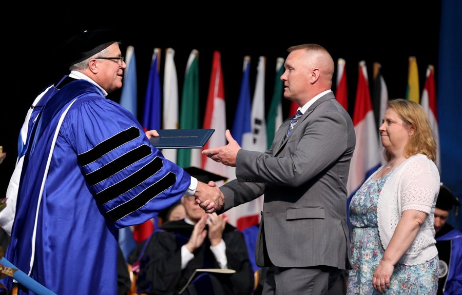 Chancellor Bob Meyer presents John and Sheila Nelson the Stouthearted Award for their late son, Nick Nelson.