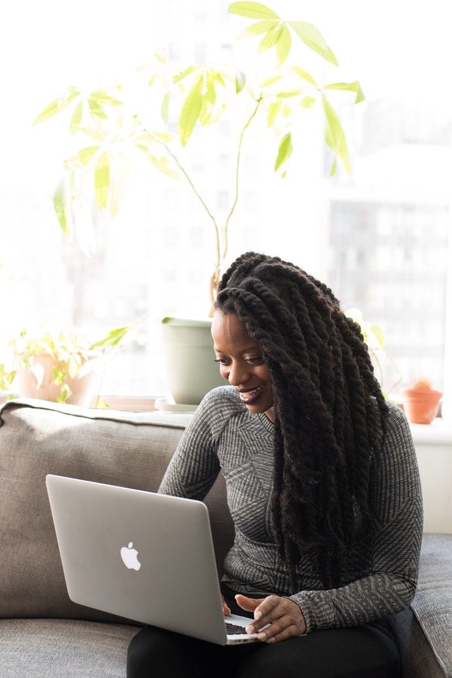 person sitting on couch looking at laptop