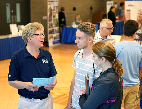 Layne Pitt, left, sports information director, talks with a student about UW-Stout’s athletics programs.