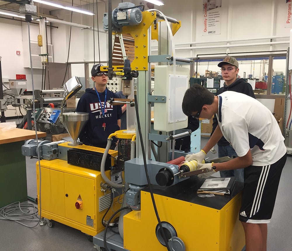 Camp members work in UW-Stout plastics laboratory creating plastic sheeting.