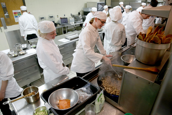 Students in the Quantity Food Production class prepare a meal at the Cedar Café at UW-Stout.