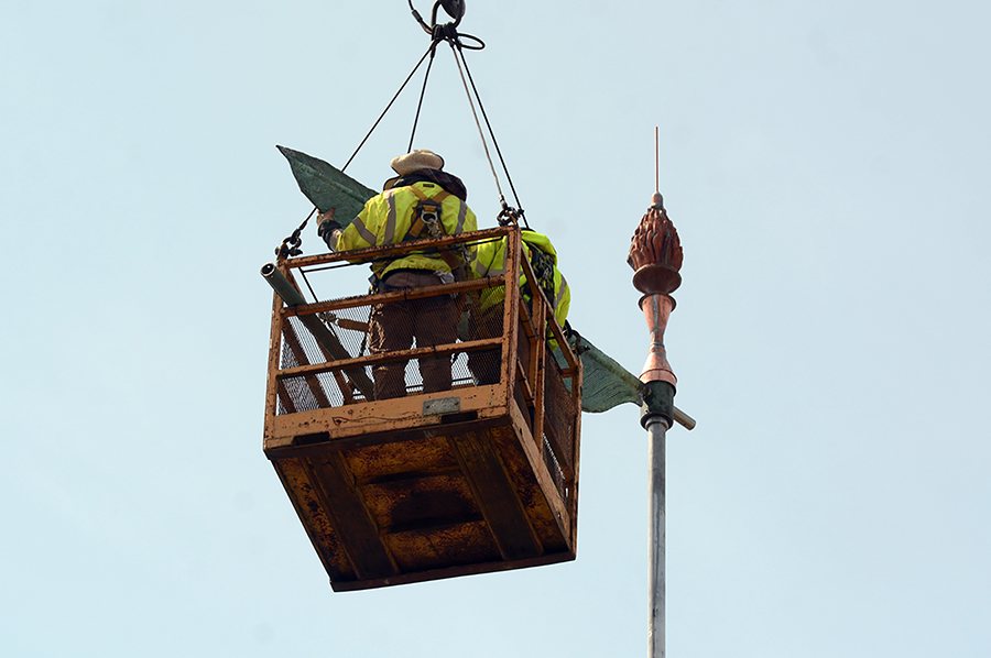 The feather end of the copper quill, a weathervane, is fitted into the central pole above Bowman Hall.