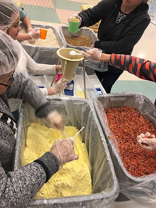 Menomonie Girl Scouts assemble meals during a recent Rotary pack-a-thon. 