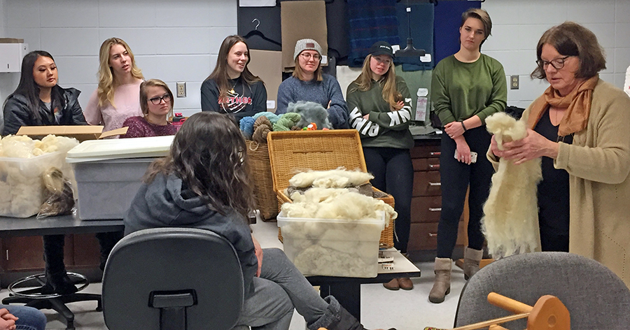 Boehm shows students wool as she talks about fibers.