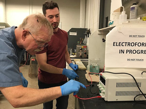 Studio art major Arne Thompson, left, works on electroforming in a lab with Assistant Professor Vincent Pontillo-Verrastro.