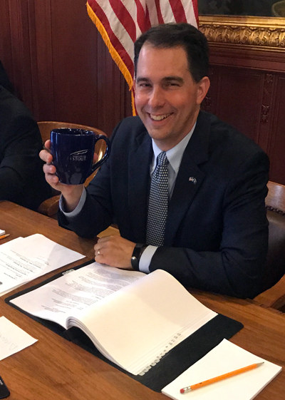 Gov. Scott Walker uses a UW-Stout coffee mug during the Wisconsin State Building Commission meeting Wednesday in Madison.