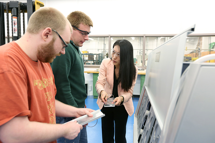Wei Zheng, who teaches in the engineering and technology department at UW-Stout, works with students in the plastics engineering lab.