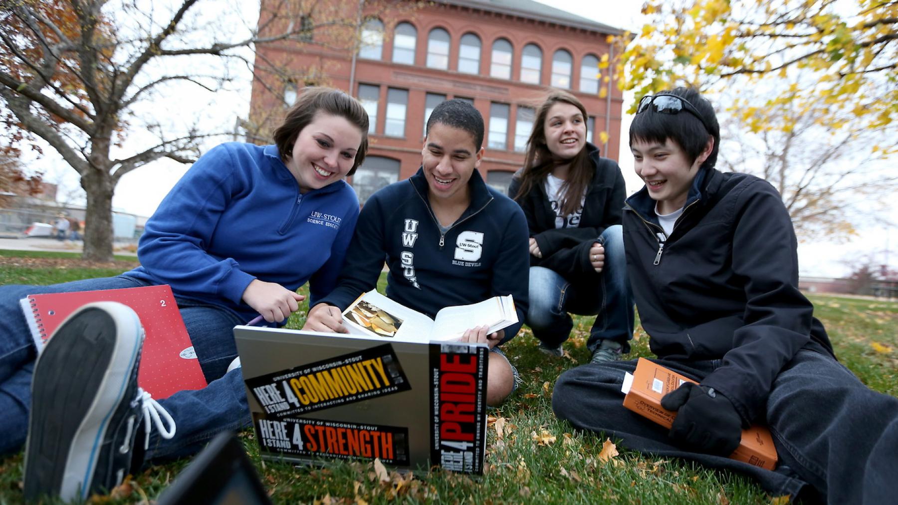 UW-Stout students lounge and study on the campus lawn.
