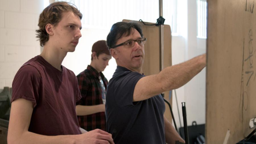Assistant Professor Daniel Atyim, right, works with a student in a Drawing II class in February.