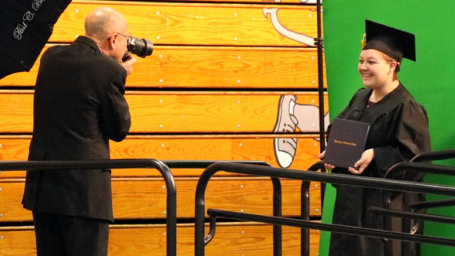 Brittany Jordan has her photo taken after crossing the stage at commencement.