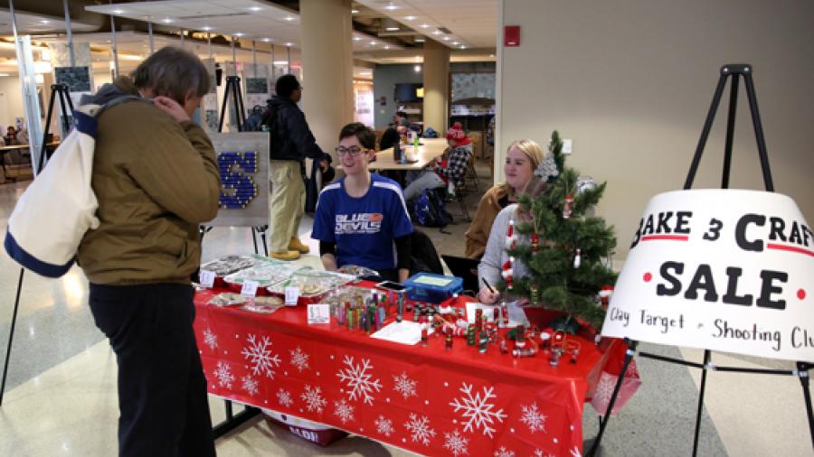 Members of the new Clay Target Club at UW-Stout, including President Emma Kosanke, second from left, sell holiday crafts made of used shotgun shells Tuesday, Dec. 5, at the Memorial Student Center.