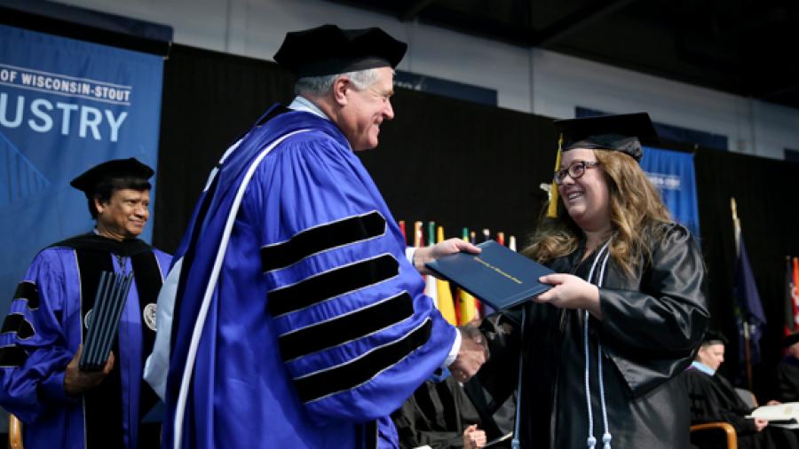 Chancellor Bob Meyer congratulates graduate Grace Sutula as she crosses the stage at commencement Saturday, Dec. 16, in Johnson Fieldhouse. Sutula earned a degree in applied mathematics and computer science.