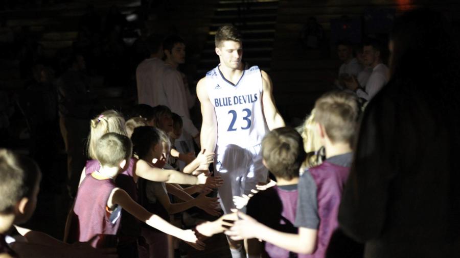 UW-Stout basketball player Brandyn Christman is greeted by children at a recent Blue Devils game.