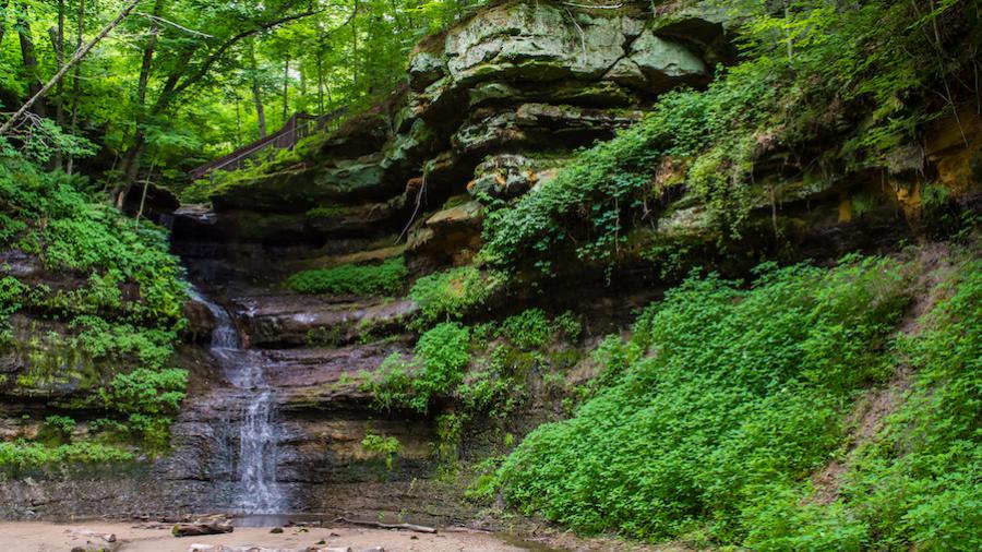 Devils Punchbowl shows off lush green foliage and a waterfall.