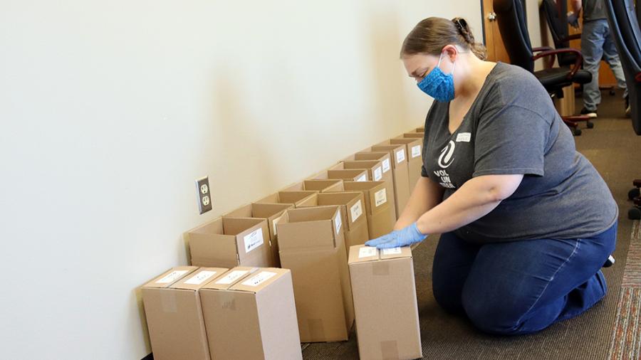 Michelle Ellis tapes up completed plant kits to go to students.