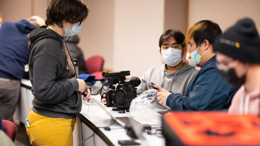 Students discuss a camera during the workshop.