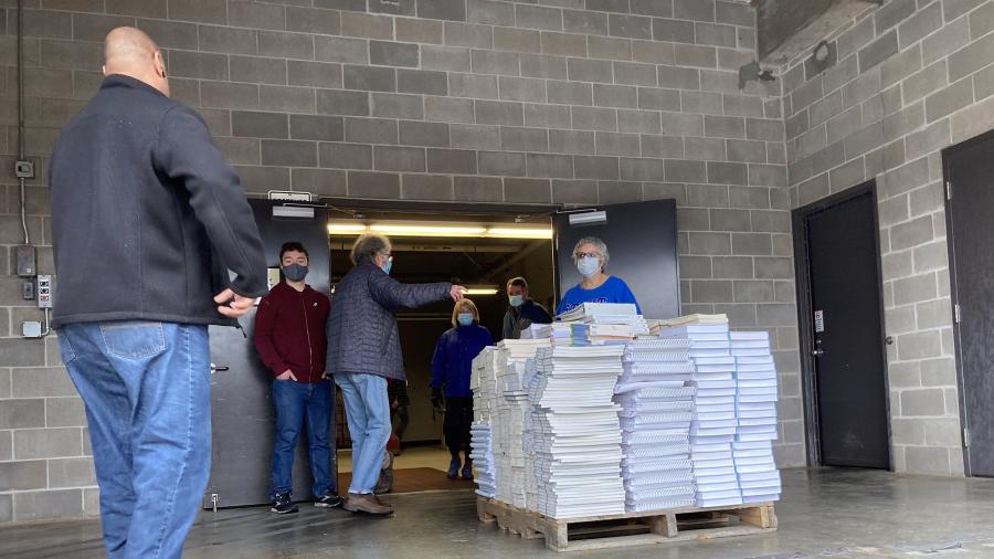 Books for Africa founder Tom Warth, in center, helps load textbooks donated by the library./