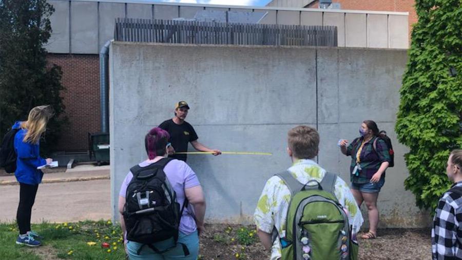Students preparing the loading dock wall for a mural.