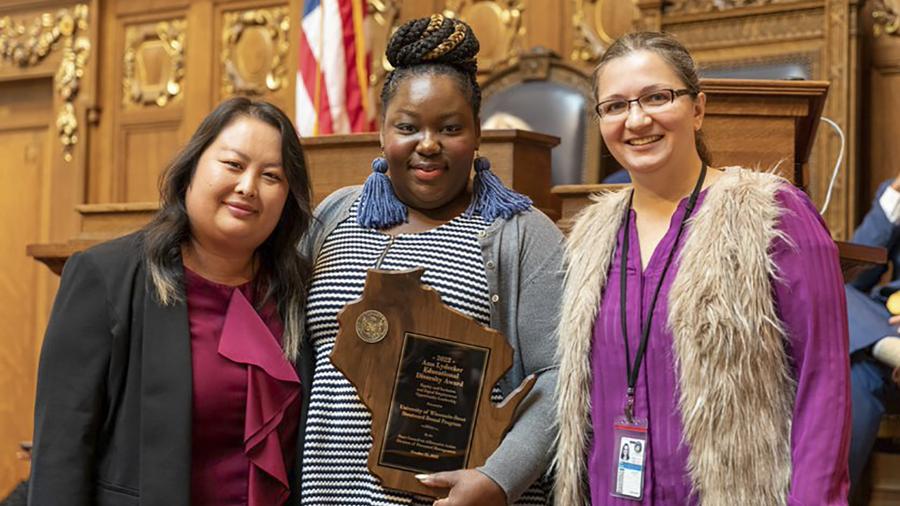UW-Stout’s Mai Khou Xiong, left, and Quin Brooks, center, receive the award from Alenka Dries, a member of the State Council on Affirmative Action.