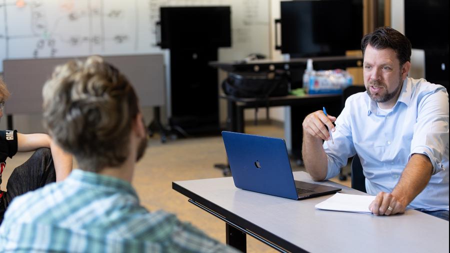 Professor Mitch Ogden, from the English, philosophy and communication studies department, works with a student. He is one of 12 UW-Stout faculty members to receive promotions and tenure.
