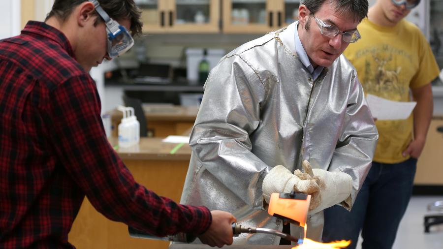 UW-Stout Professor Matthew Ray, center, works with students in a Chemistry of Materials class in Jarvis Hall. 