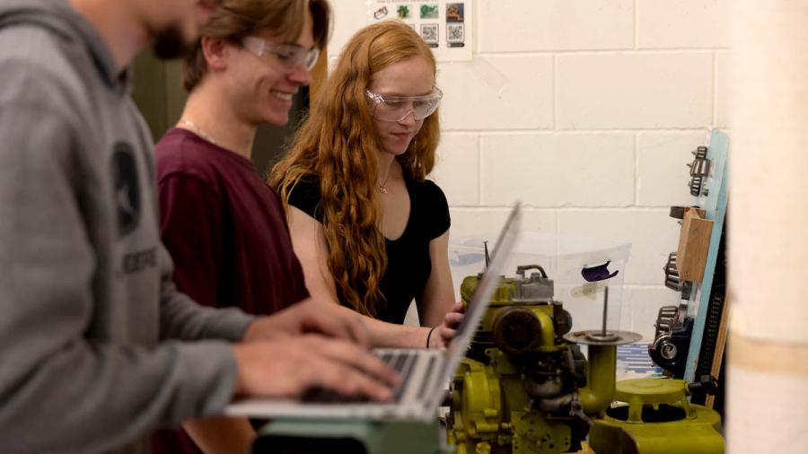 Mechanical engineering students disassemble a small engine
