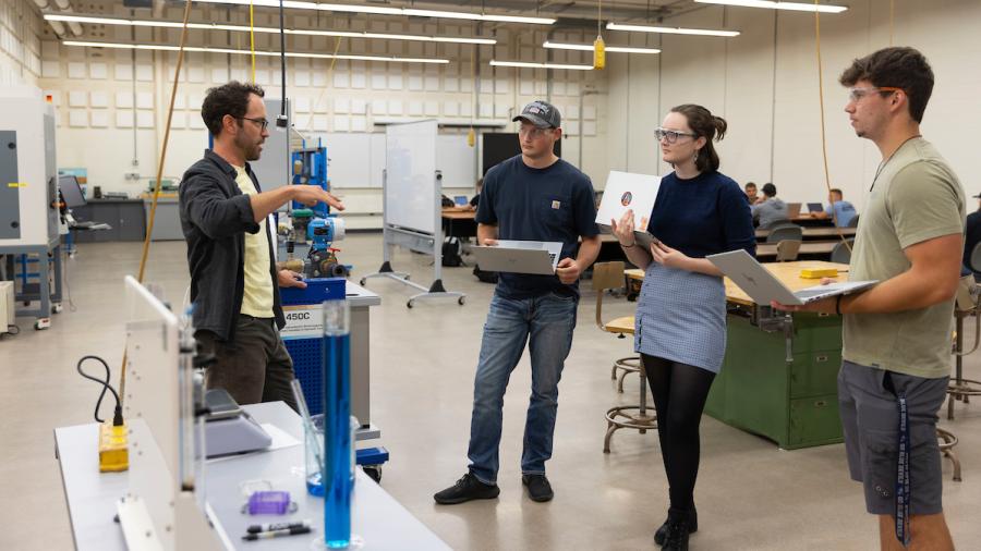 Professor Vince Wheeler explaining a fluid viscosity experiment to students