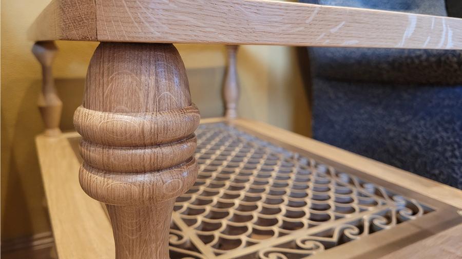 A close-up of a hand-turned white oak table leg