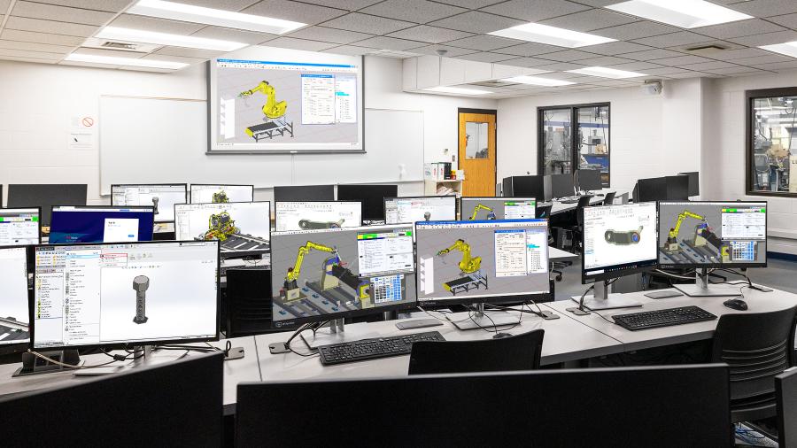 Engineering computer lab filled with rows of contemporary machines, many of which display engineering designs at various stages of completion on their monitors.