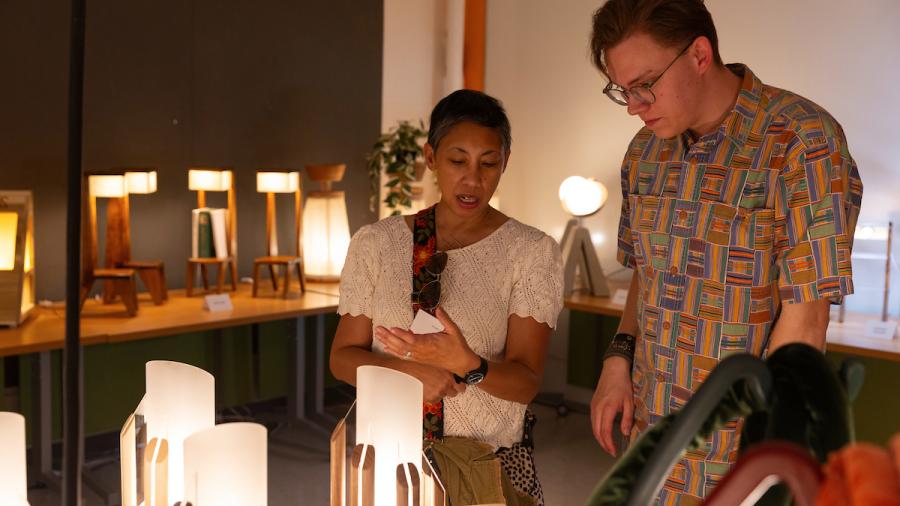 People admiring student-designed lamps at the School of Art and Design Senior Show