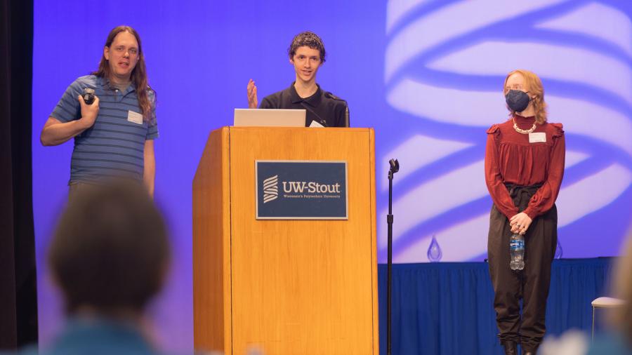 A professor and students give a presentation on stage.