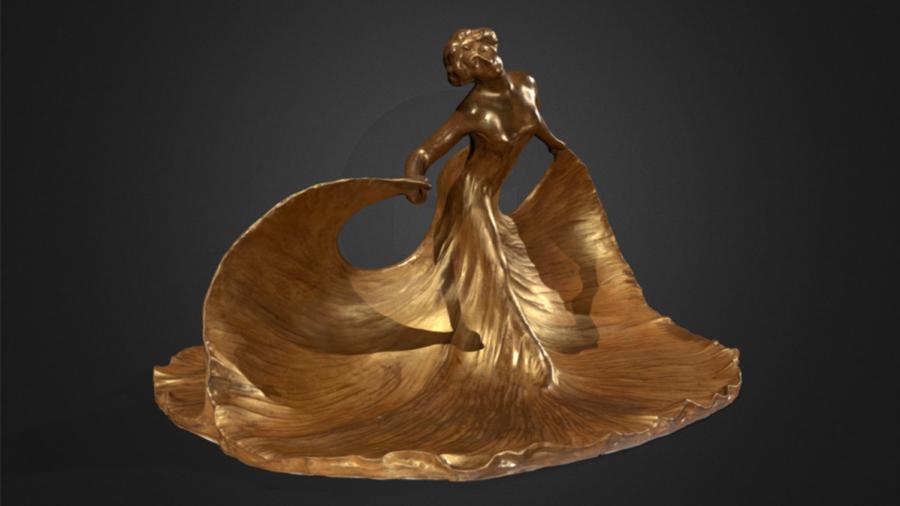 A gold-colored sculpture of a dancing woman.