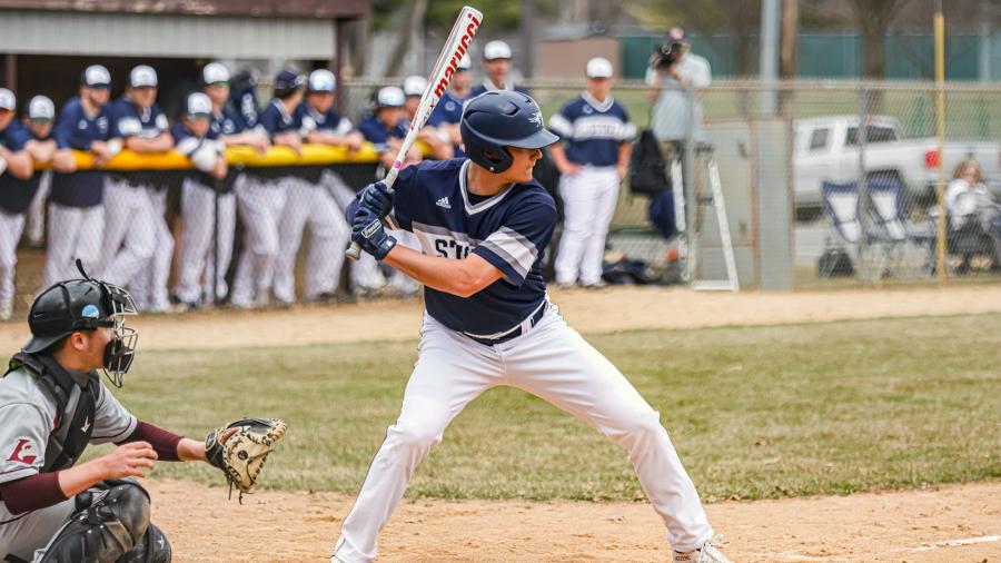 A student athlete bats at home plate on the baseball diamond.
