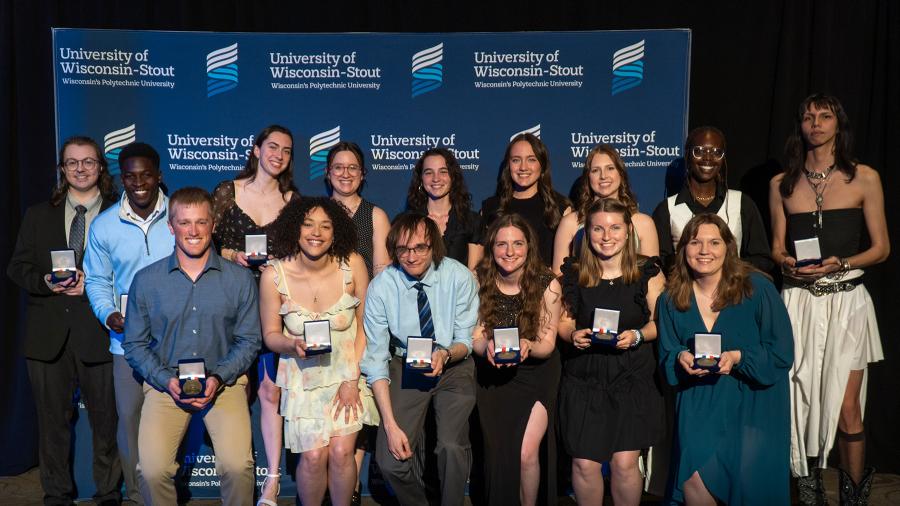 A group of students holding award plaques