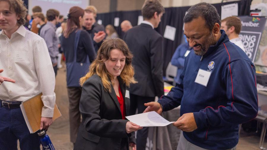 Two people talk at a career fair