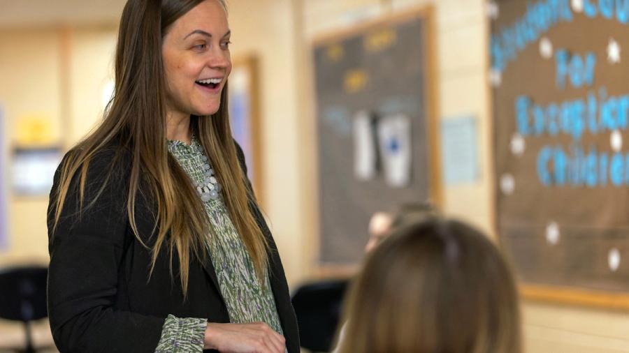 A woman speaks to students