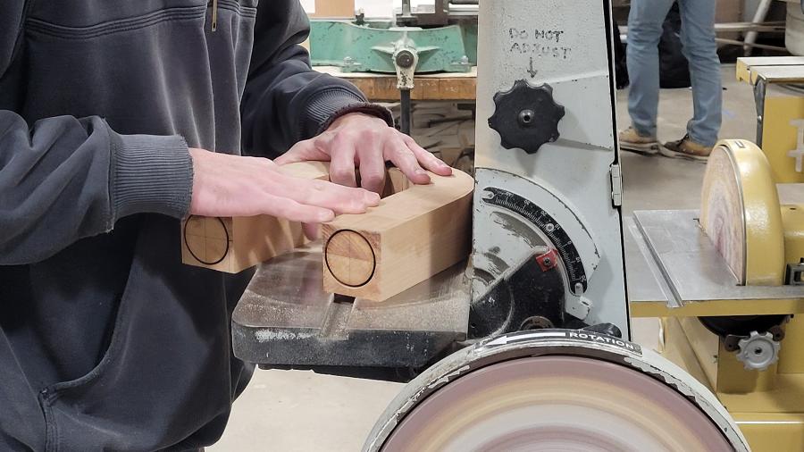 An industrial design student uses a sanding belt in the Process Lab.