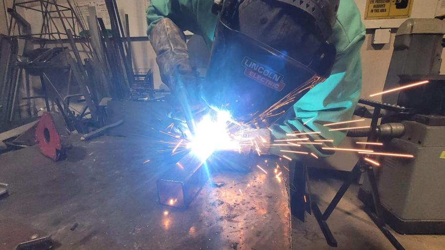 An industrial design student welding a T-bar.