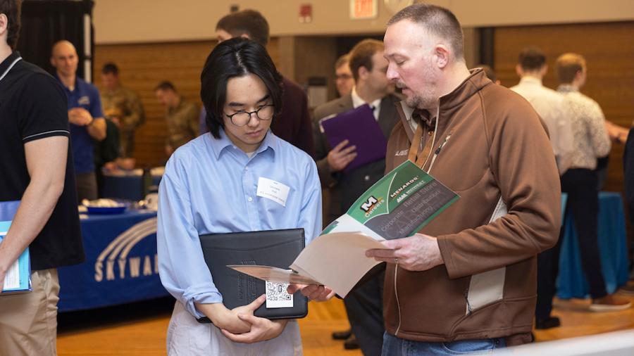 Students talk with employer recruiters at a career conference