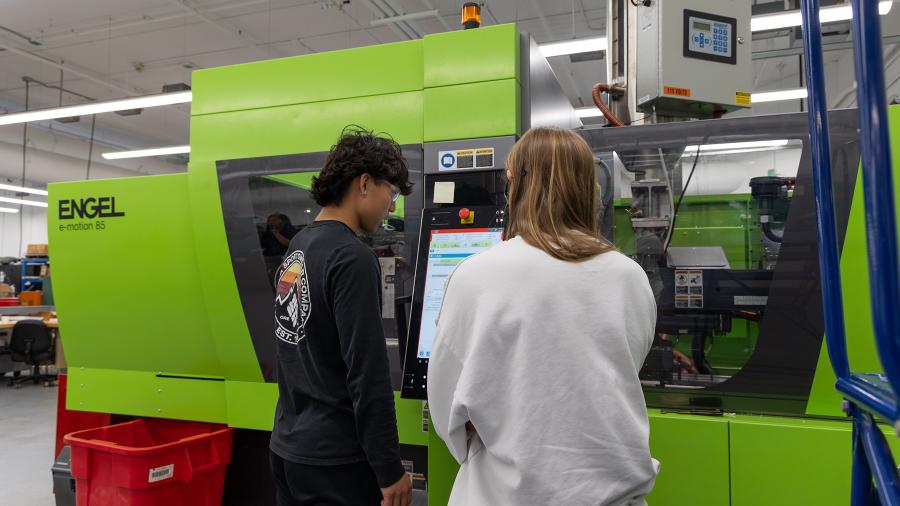 Students with injection molding equipment