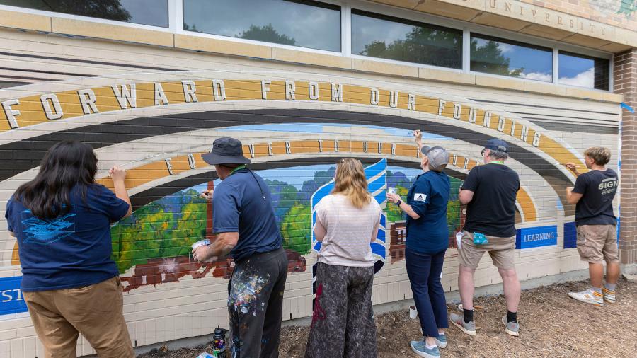 Group of people paint mural