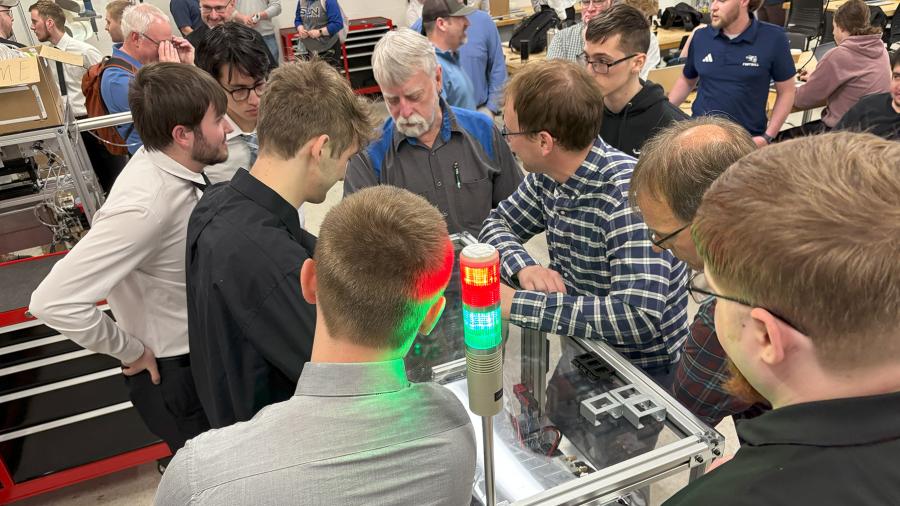 People stand around mechanical device