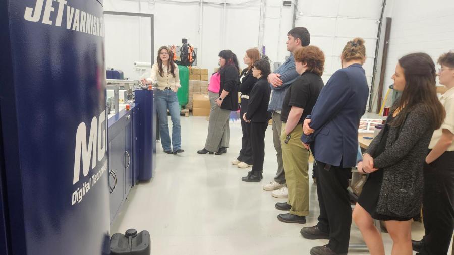 A group of students tours a printing company.