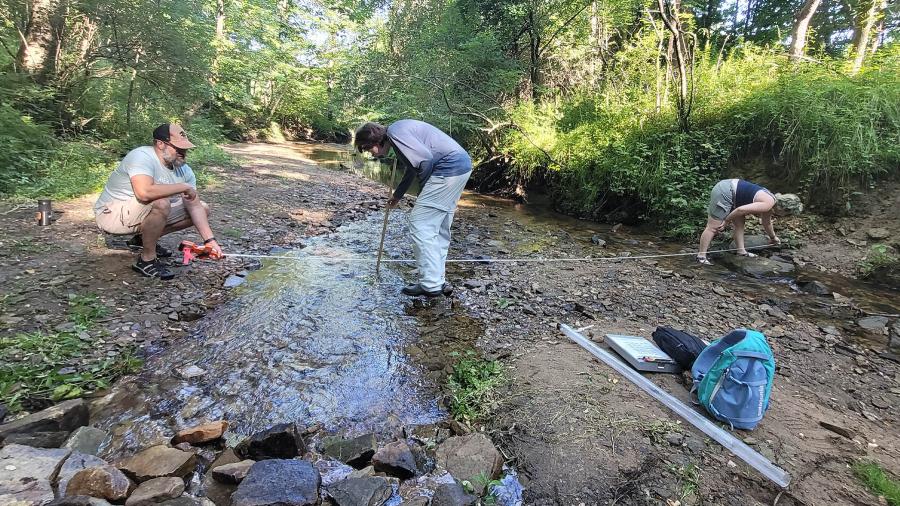 Professor Keith Gilland and students Norah Shires and Abi Cherry measure the width and depth of Galloway Creek