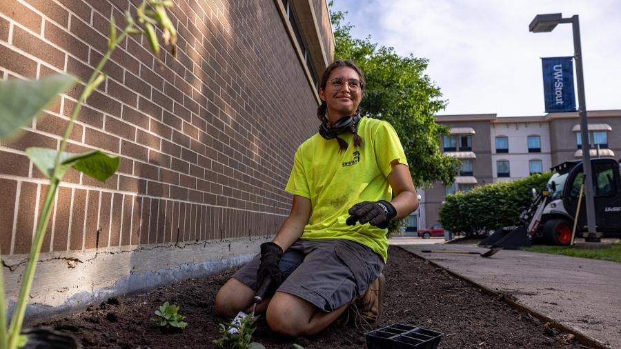 Student worker planting plants