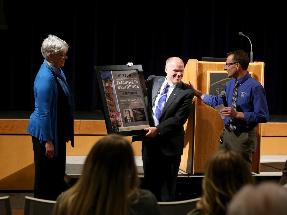 Jeff Ylinen (center) receives a plaque honoring him as an Executive in Residence from Deanna Schultz, associate professor in CTE, and Urs Haltinner, a CTE professor, Tuesday, February 13, 2018 in the Great Hall of the Memorial Student Center. 