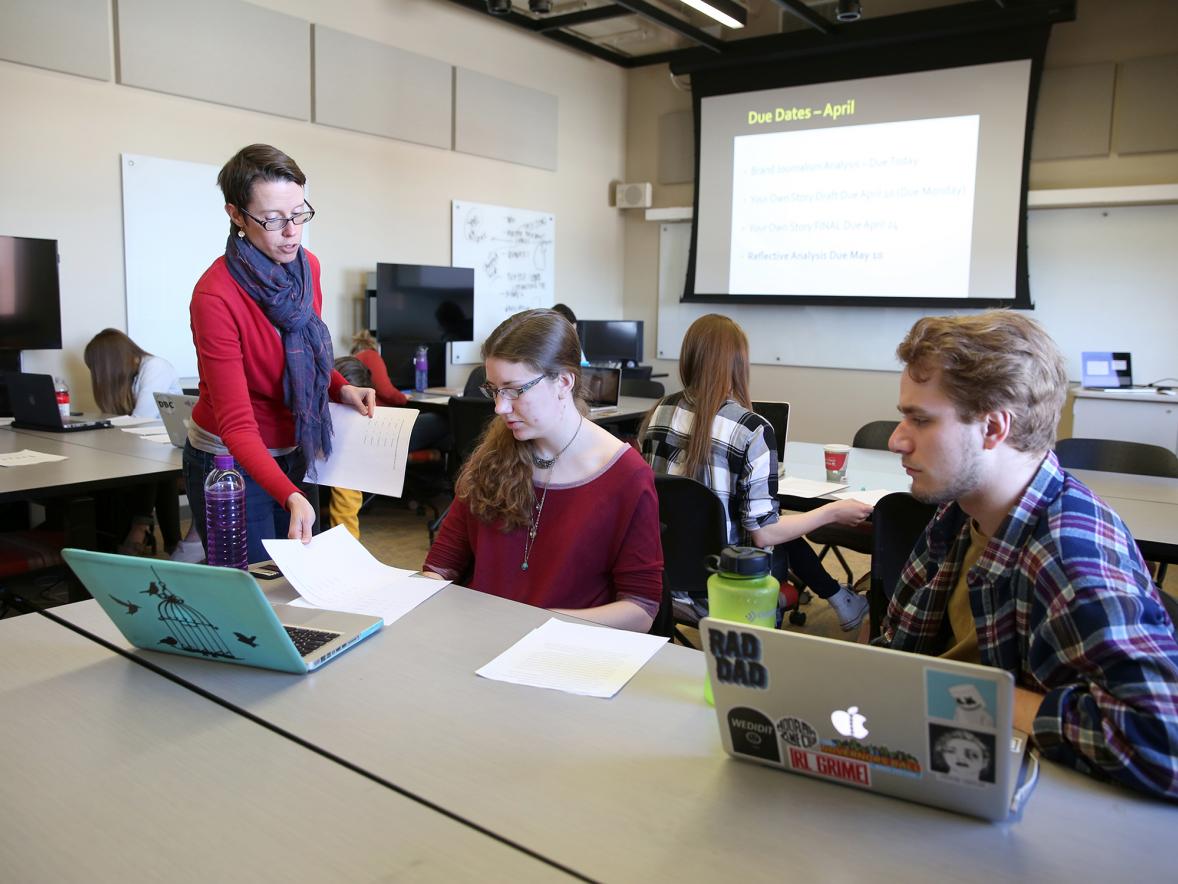 Associate Professor Kate Edenborg works with students in an applied journalism class at UW-Stout. 