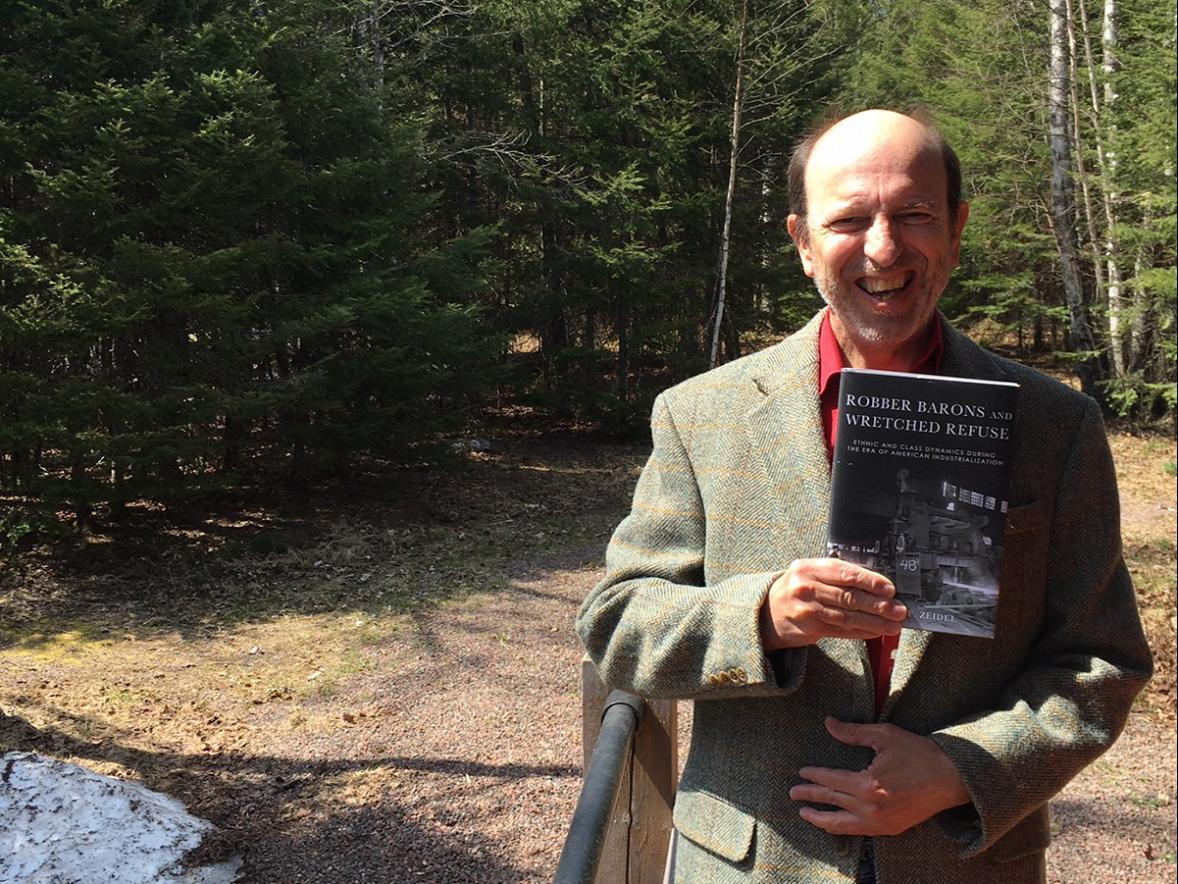 Robert Zeidel, UW-Stout professor and interim dean of the College of Arts, Communication, Humanities and Social Sciences, with his book “Robber Barons and Wretched Refuse: Ethnic and Class Dynamics During the Era of American Industrialization.”