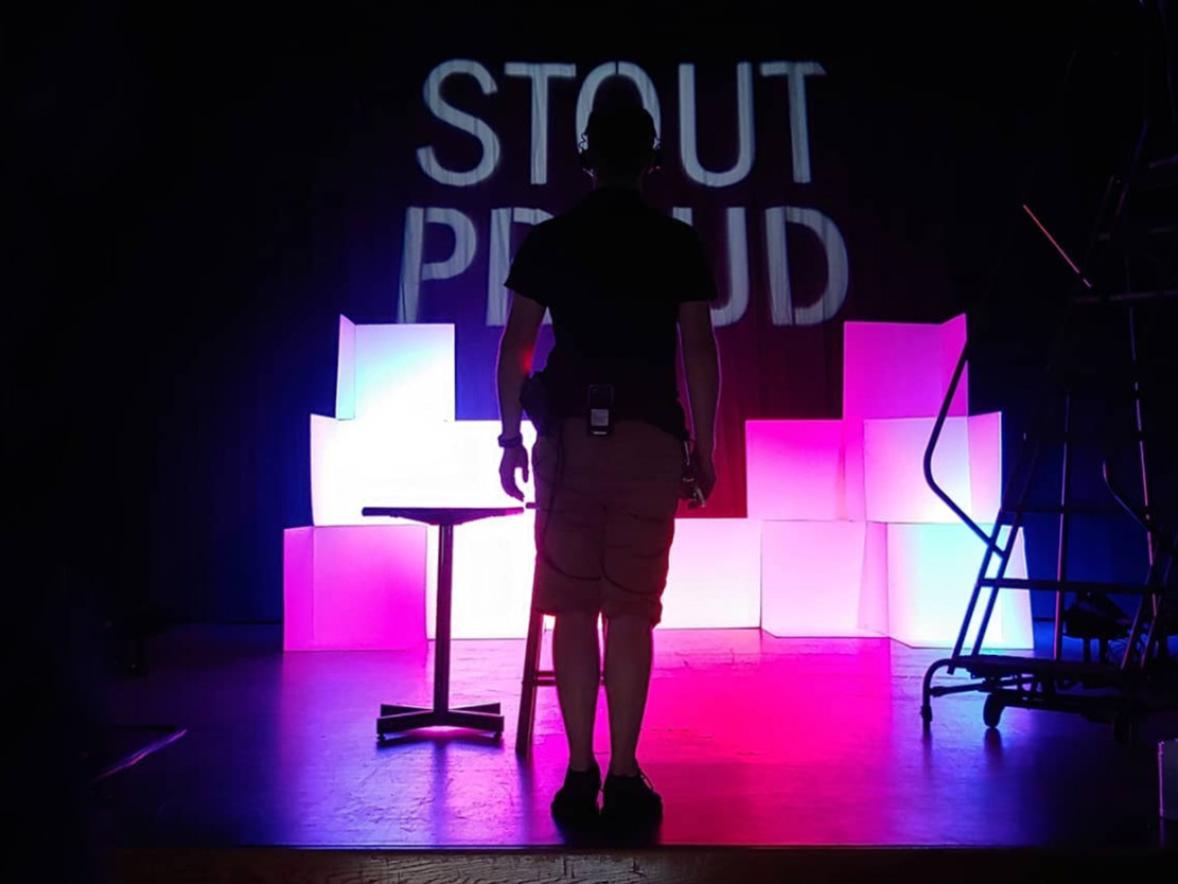 StoutProud logo with purple backlighting, and a student silhouetted in the foreground.