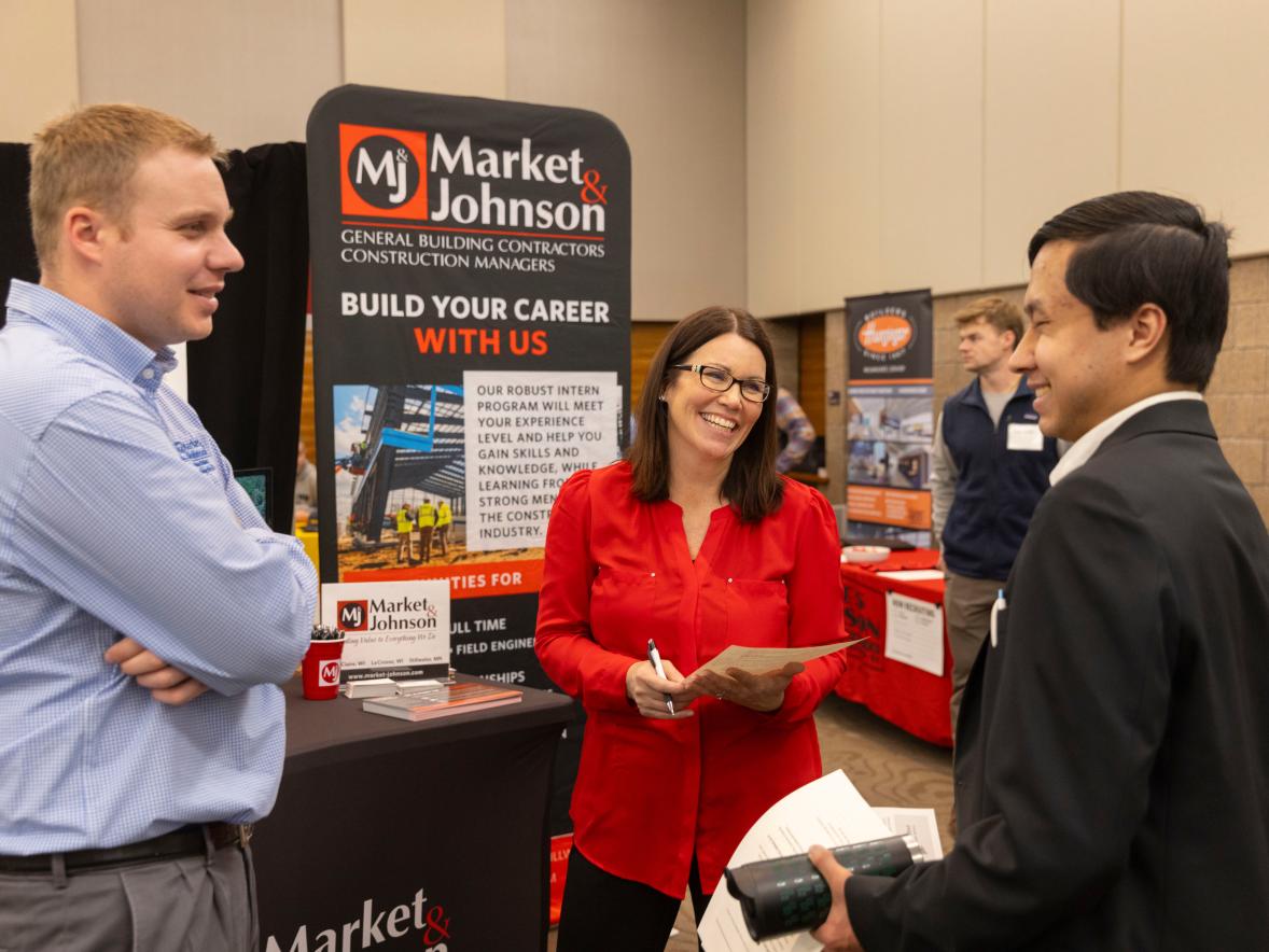A UW-Stout student visits with recruiters from Market & Johnson construction company of Eau Claire during the 2024 spring Career Conference.